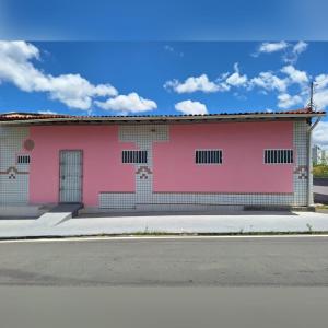 a pink building on the side of a street at Quarto TOP perto do Centro e Praias AR TV Wifi Cozinha Lavadora in São Luís