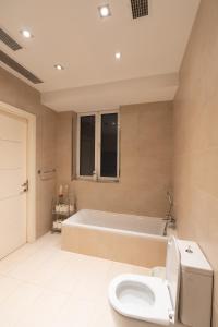a bathroom with a toilet and a bath tub at Blue Line Sliema in San Pawl il Bahar