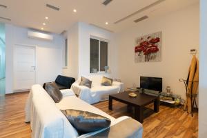 a living room with two couches and a tv at Blue Line Sliema in San Pawl il Bahar