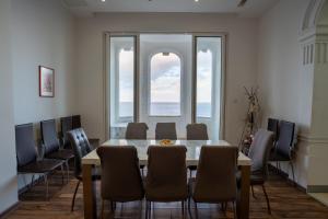 a dining room with a table and chairs and windows at Blue Line Sliema in San Pawl il Bahar