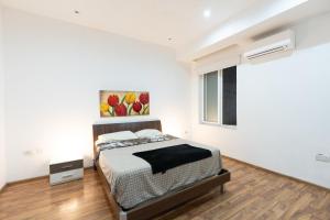 a bedroom with a bed and a painting on the wall at Blue Line Sliema in San Pawl il Bahar
