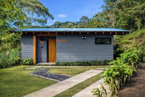 a small grey house with a blue roof at Olingo Monteverde - Studio Apartment with Jacuzzi in Monteverde Costa Rica
