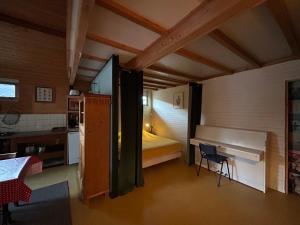 a small room with a bed and a desk in it at Le bon chemin Ateliers in Sainte-Nathalène