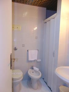 een witte badkamer met een toilet en een wastafel bij Hotel Calla' in Policoro