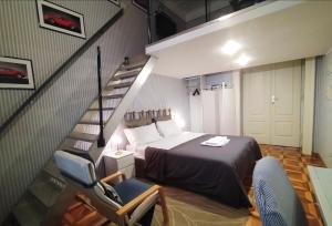 a bedroom with a bed and a staircase with a chair at VelaMar in Trieste
