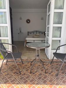 a table and two chairs in a room with a bed at Villa 3D Grand baie Pereybere in Pereybere