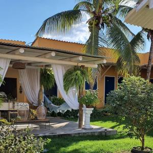a house with a porch with a palm tree at Pousada 2 Rios Comfort in Barra do Garças