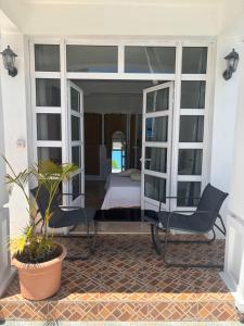 a room with a bed and two chairs on a patio at Villa 3D Grand baie Pereybere in Pereybere