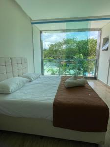 a bedroom with a large bed with a large window at Rincão Resort in São Paulo