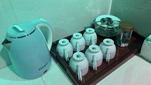 a tray with a teapot and a group of cups at Evergreen Cottage in Ella