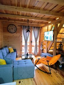 a living room with a blue couch and a clock at Dedin Konak in Mokra Gora