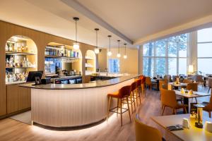 a restaurant with a bar and tables and chairs at Auberge de la Montagne Coupée in Saint-Jean-de-Matha