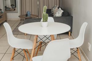 a white table with four chairs and a cactus at Ballito Exotic Lifestyle in Ballito