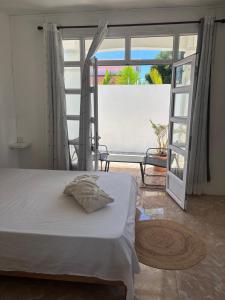 a bedroom with a white bed and a large window at Villa 3D Grand baie Pereybere in Pereybere