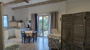 a kitchen and living room with a table and chairs at Gite Le Petit Luberon LISIANTHUS in Cabrières-dʼAvignon