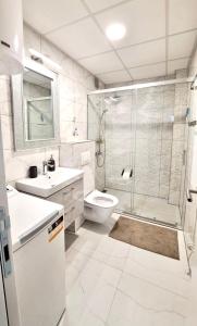 a bathroom with a shower and a toilet and a sink at Upendo Apartment in Vrnjačka Banja +12 photos