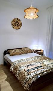 a bedroom with a cheetah bed with a clock on the wall at Upendo Apartment in Vrnjačka Banja