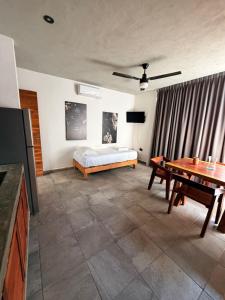 a living room with a bed and a table at condo pacha tulum in Tulum