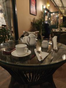 a table with tea cups and saucers on it at Tiger Woods Ranthambore in Sawāi Mādhopur