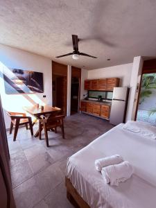 a bedroom with a bed and a kitchen with a table at condo pacha tulum in Tulum +57 photos