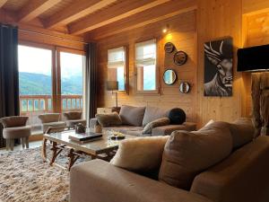 a living room with a couch and a table at Chalet Alpaga Manigod La Clusaz 11 personnes in Manigod