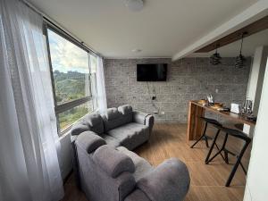 a living room with a couch and a table and a window at Descansa, comodidad y confort in Manizales