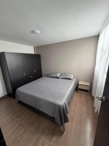 a bedroom with a bed and a cabinet at Descansa, comodidad y confort in Manizales