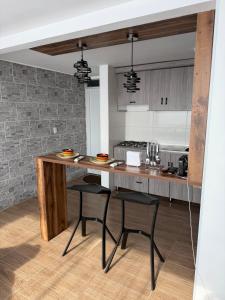 a kitchen with a large wooden counter with stools at Descansa, comodidad y confort in Manizales