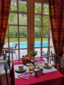 a table with a plate of food on a red table cloth at Auberge Marcheroux in Amboise