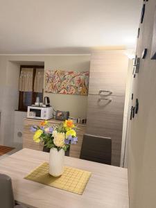 a vase of flowers on a table in a kitchen at Bellagio Little Apartment in Bellagio