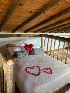 a bed with a white blanket with two hearts on it at loft Ágata in Brumadinho