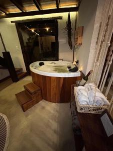 a bathroom with a tub and a glass of wine at loft Ágata in Brumadinho +15 photos