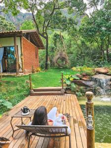 a woman sitting in a chair on a wooden deck at loft Ágata in Brumadinho