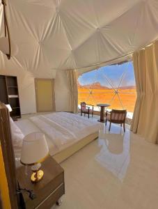 a bedroom with a large bed with a view of the desert at The Heritage Inn in Disah +5 photos