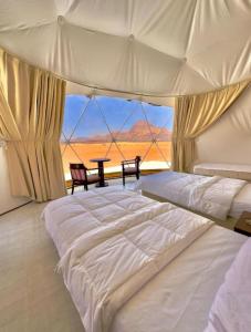 a bedroom with two beds and a view of the desert at The Heritage Inn in Disah