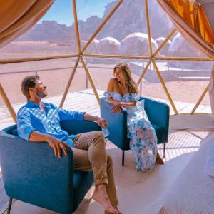 a man and woman sitting in chairs in a tent at The Heritage Inn in Disah