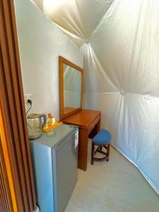a room with a desk and a bed with a mirror at The Heritage Inn in Disah