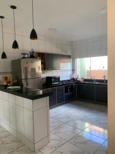 a large kitchen with blue cabinets and a counter top at Casa Camocim Marilago in Camocim