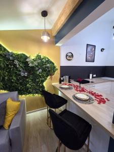 a kitchen with a table with chairs and a green wall at Le Baiser Doré in Sainte-Marie-aux-Chênes