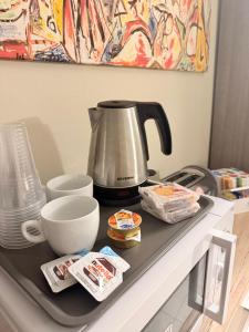 a counter with a coffee pot and bowls on it at Bellagio Apartment San Giovanni in Bellagio