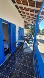 a room with a hammock on a porch at Magia D'ajuda Hospedagem - Centrinho, próximo à Mucugê in Arraial d'Ajuda