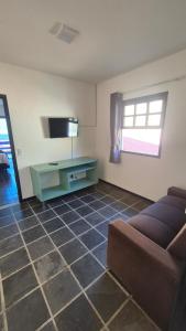 a living room with a couch and a flat screen tv at Magia D'ajuda Hospedagem - Centrinho, próximo à Mucugê in Arraial d'Ajuda