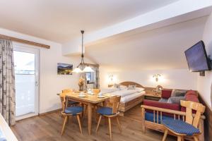 a living room with a table and a couch at Neuhof Appartements in Maishofen