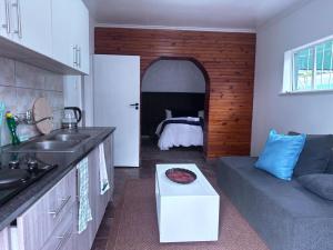 a kitchen with a couch and a living room at SA Guest House in Roodepoort