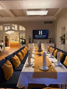 a long table with yellow and blue couches in a room at Hotel & Restaurant Bellevue Schmölln in Schmölln
