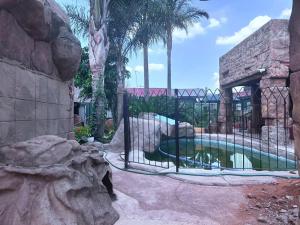 a swimming pool with a fence in a zoo at SA Guest House in Roodepoort