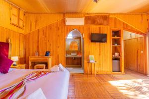 a bedroom with wooden walls and a bed and a tv at Maison safou in Marrakesh