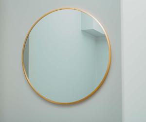 a round mirror with a gold frame on a white wall at Ballito Seasons in Ballito +19 photos
