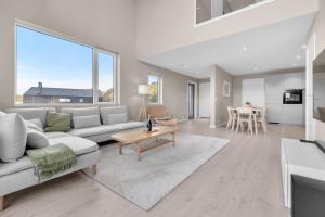 a living room with a couch and a table at Sunset Bay Penthouse in Kristiansand +37 photos