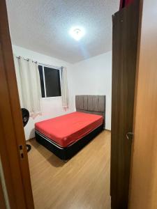 a bedroom with a red bed in a room at Ap Hostel For You in Serra +6 photos